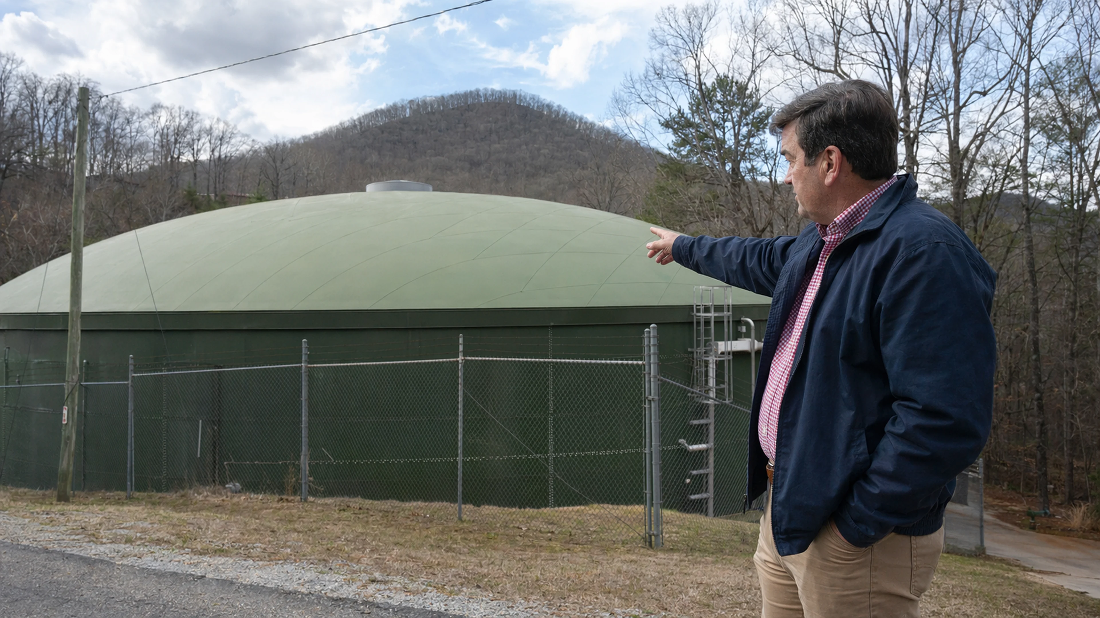 Helen Public Works Director Jack Morgan, right, at the city's primary ground-level water storage tank on Robertstown Road, Wednesday afternoon. The tank, installed in 2011, holds approximately 500,000 gallons. Of the water it dispenses into the distribution system, approximately 200,000 gallons per day — 40 percent of the total — does not arrive at any metered point of sale, per engineering disclosures filed with the City Commission the preceding Tuesday. (Photo: Bavarian Brainrot / Margaret Holcomb)